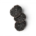 Fresh Tuber melanosporum slices showing dark marbled interiors and natural shape variation
