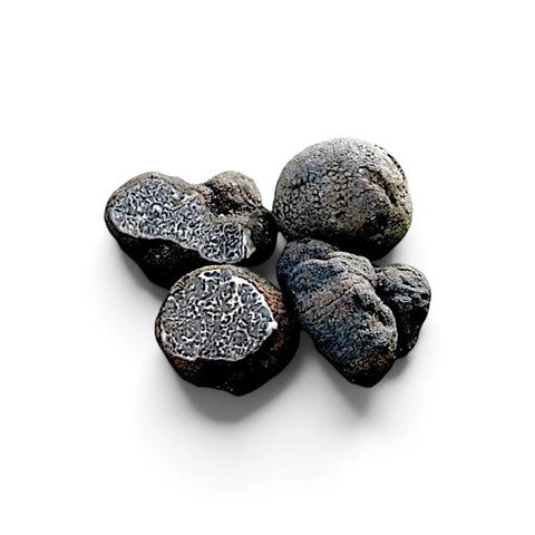 Цели и нарязани гладки черни трюфели Tuber macrosporum с тъмни мраморирани вътрешности