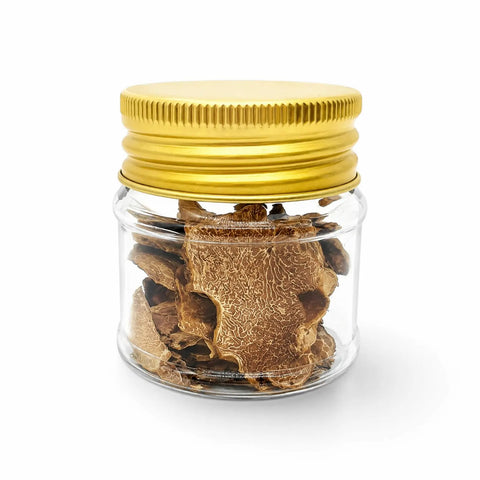 Dried Tuber magnatum Pico white truffle slices in a clear glass jar with a yellow lid