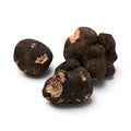 Fresh Tuber brumale B Grade specimens with irregular dark surfaces and exposed marbled interiors