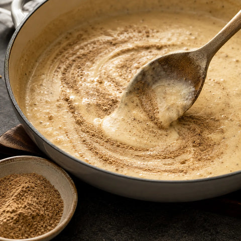 Morel powder being incorporated into a creamy sauce for even flavour distribution